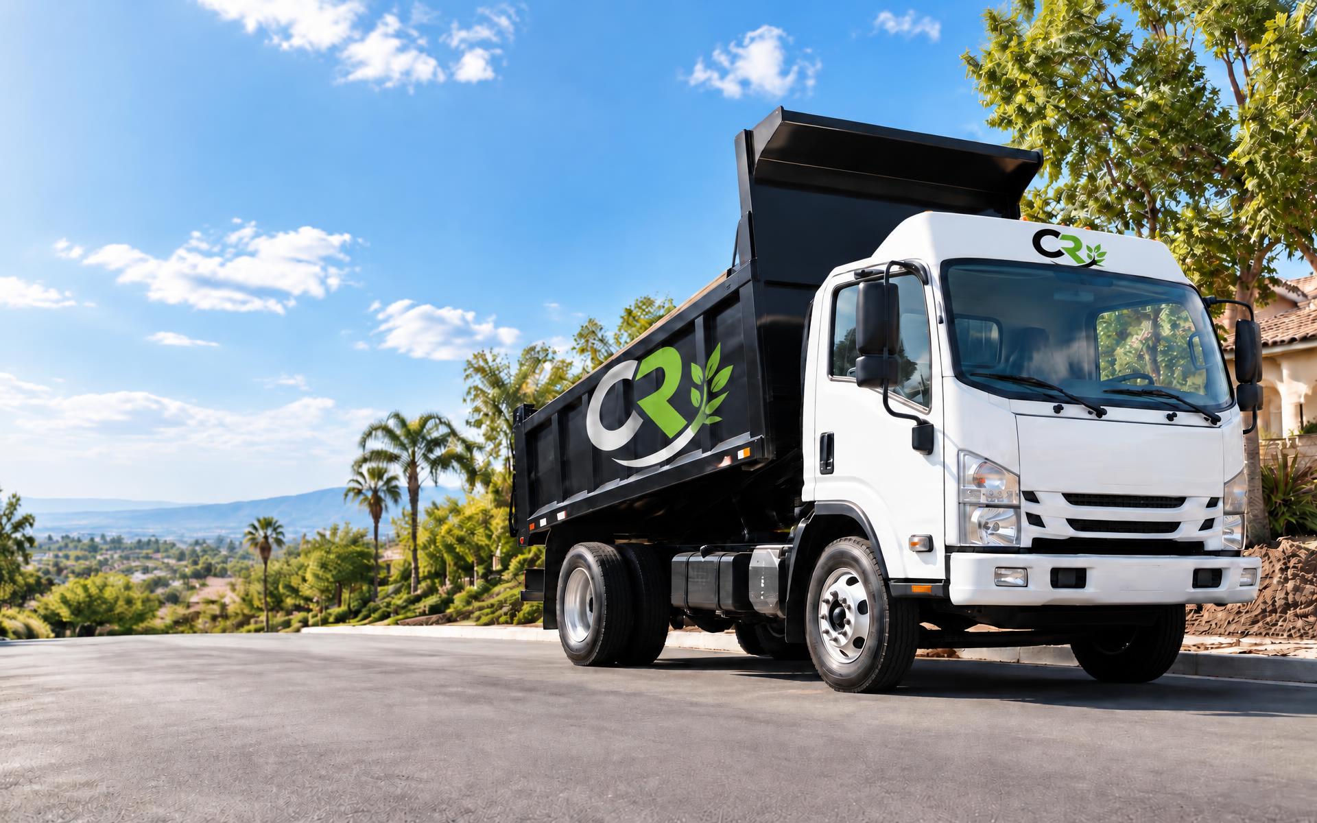 CRinnovations white dump truck with raised bed on a sunny Southern California street